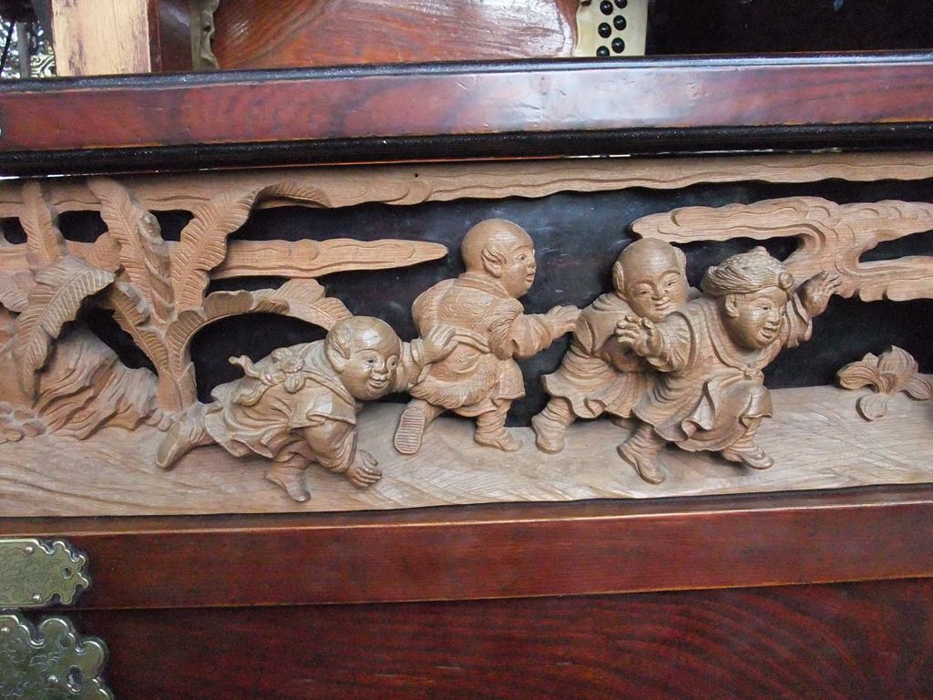 竹の彫刻の子供が遊ぶ筆立ての文壇に荷物を置く-